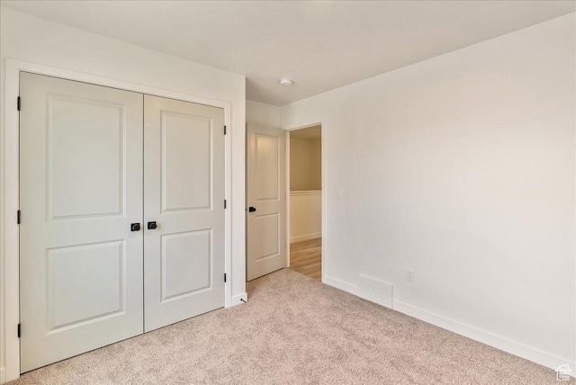 2329 E Woodbury Ln, Eagle Mountain, UT 84005 - unfurnished bedroom with a closet, baseboards, and light carpet