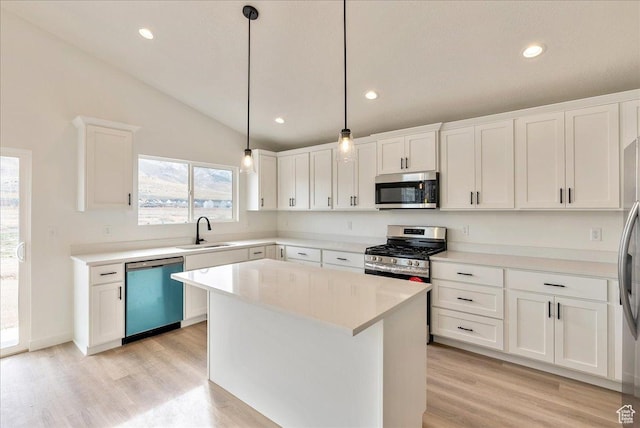 2329 E Woodbury Ln, Eagle Mountain, UT 84005 - kitchen featuring vaulted ceiling, light countertops, white cabinets, appliances with stainless steel finishes, and a sink