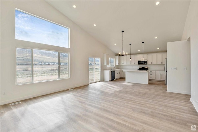 2329 E Woodbury Ln, Eagle Mountain, UT 84005 - unfurnished living room featuring high vaulted ceiling, plenty of natural light, and light wood-style floors