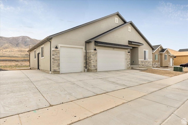 2329 E Woodbury Ln, Eagle Mountain, UT 84005 - view of front of house with a garage, stucco siding, stone siding, and concrete driveway