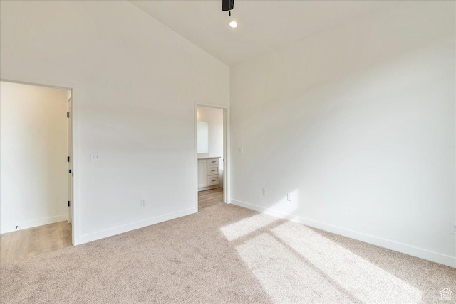 2329 E Woodbury Ln, Eagle Mountain, UT 84005 - empty room featuring high vaulted ceiling, recessed lighting, light colored carpet, and baseboards