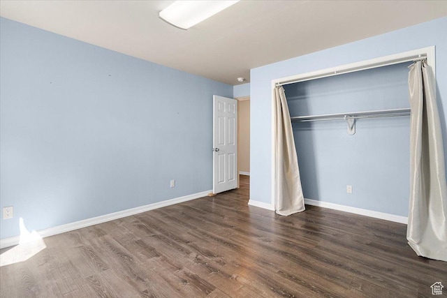 unfurnished bedroom with a closet, baseboards, and wood finished floors