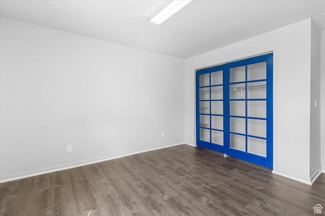 unfurnished room featuring baseboards and wood finished floors