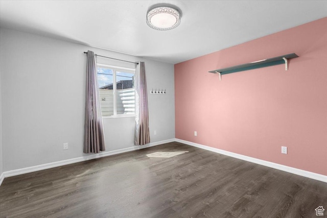 spare room featuring baseboards and wood finished floors