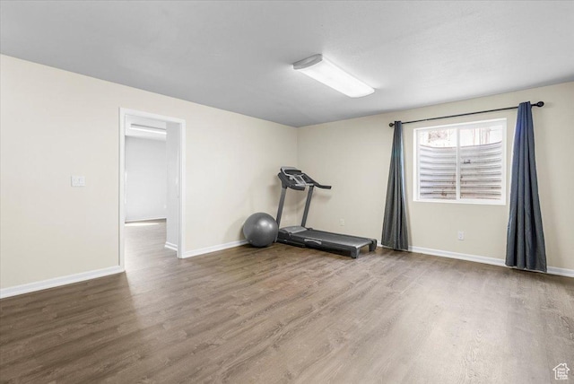 exercise room with wood finished floors and baseboards