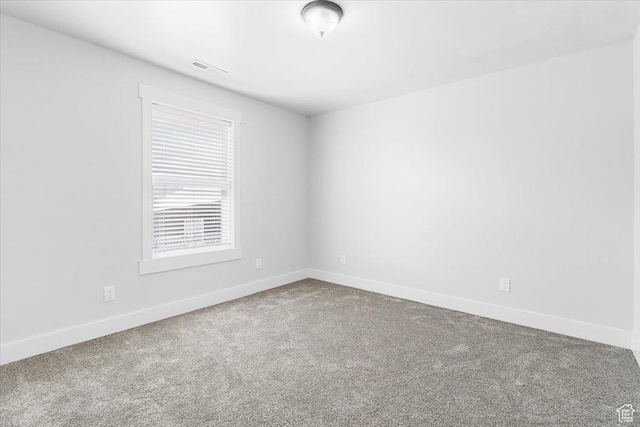 carpeted empty room with visible vents and baseboards