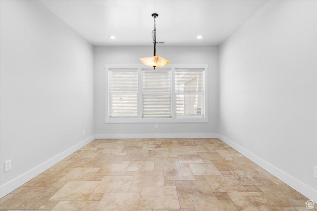 spare room featuring baseboards, recessed lighting, and stone finish floor
