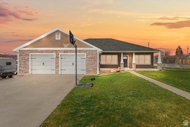 view of front of property with stucco siding, fence, a front lawn, an attached garage, and driveway