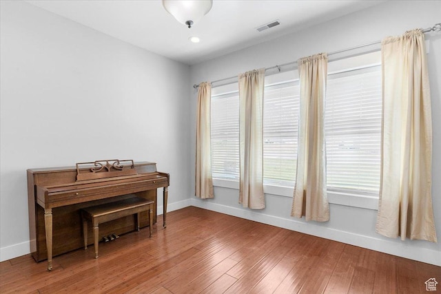 sitting room featuring baseboards, visible vents, and hardwood / wood-style flooring