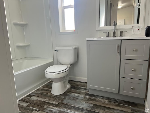 full bath featuring toilet, wood finished floors, vanity, and baseboards