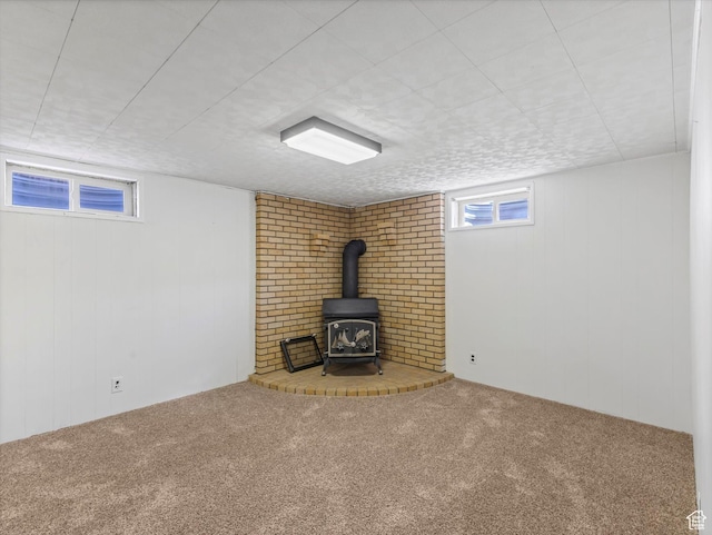 below grade area with carpet floors and a wood stove