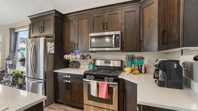 1887 N Maris St, Tooele, UT 84074 - kitchen with appliances with stainless steel finishes, light countertops, and dark brown cabinetry