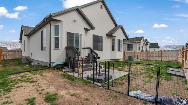 1887 N Maris St, Tooele, UT 84074 - back of property featuring a yard, a fenced backyard, a mountain view, and stucco siding