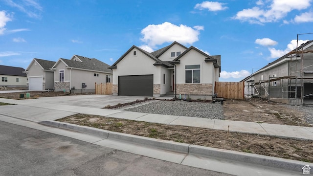 1887 N Maris St, Tooele, UT 84074 - view of front of home with concrete driveway, stucco siding, stone siding, an attached garage, and fence