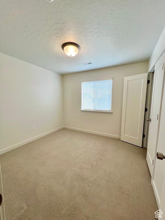 6293 W Jackson Crest Way, Herriman, UT 84096 - unfurnished bedroom featuring light carpet, baseboards, and a textured ceiling