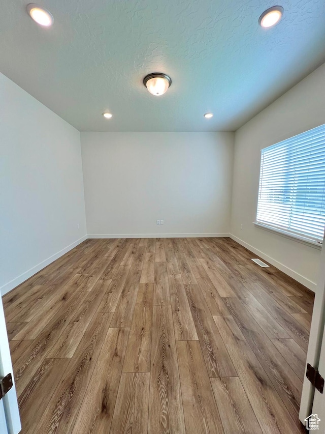 6293 W Jackson Crest Way, Herriman, UT 84096 - unfurnished room with recessed lighting, light wood-style floors, baseboards, and a textured ceiling
