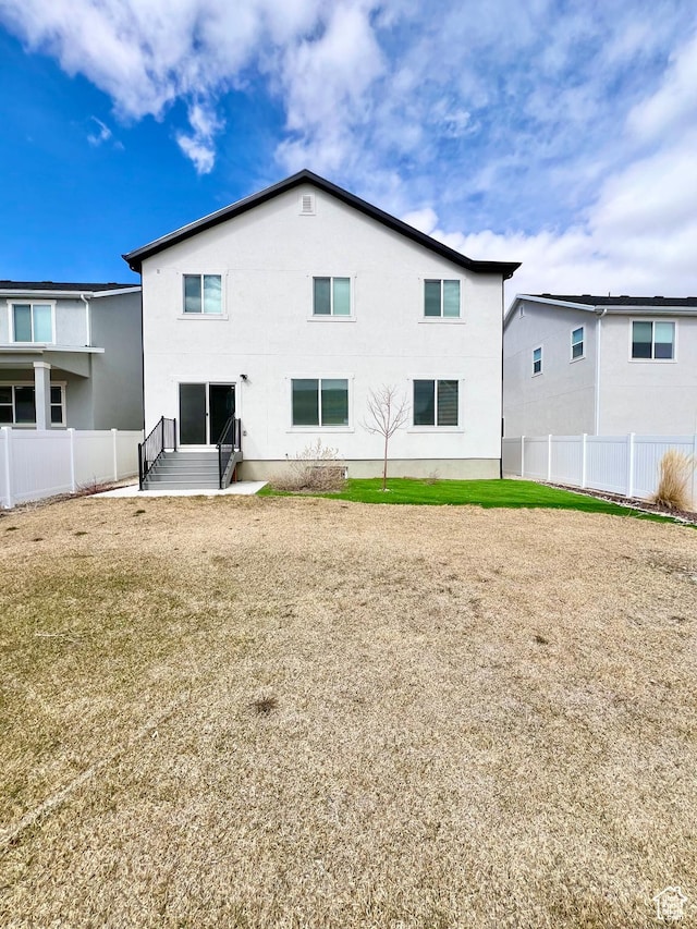 6293 W Jackson Crest Way, Herriman, UT 84096 - back of property featuring entry steps, fence, and a lawn