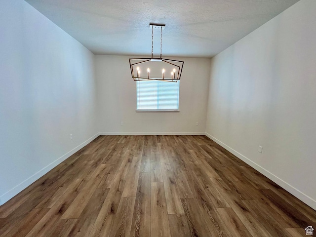6293 W Jackson Crest Way, Herriman, UT 84096 - unfurnished dining area featuring a chandelier, a textured ceiling, wood finished floors, and baseboards