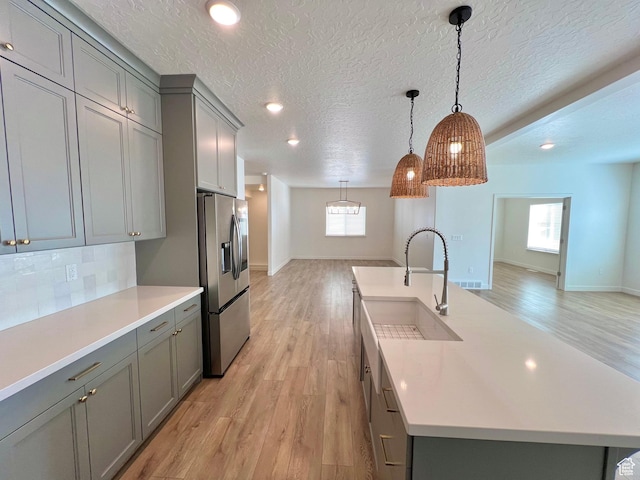 6293 W Jackson Crest Way, Herriman, UT 84096 - kitchen featuring stainless steel refrigerator with ice dispenser, light countertops, a sink, and gray cabinets