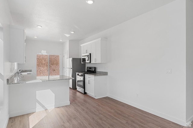 7129 Oquirrh Ranch Pkwy N, Eagle Mountain, UT 84005 - kitchen featuring a sink, white cabinets, appliances with stainless steel finishes, and light wood finished floors