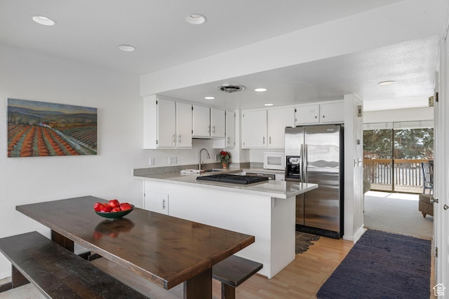 118 Davis Ct, Park City, UT 84060 - kitchen featuring white microwave, stainless steel fridge with ice dispenser, a peninsula, visible vents, and a sink