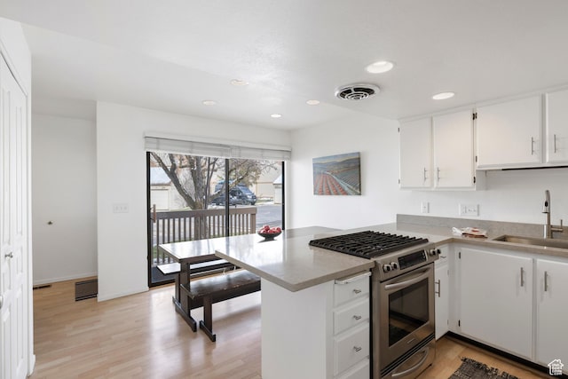 118 Davis Ct, Park City, UT 84060 - kitchen with stainless steel gas stove, a peninsula, white cabinets, visible vents, and a sink