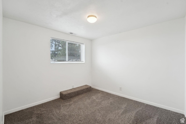 carpeted empty room featuring visible vents and baseboards