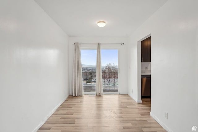 empty room with light wood-type flooring and baseboards