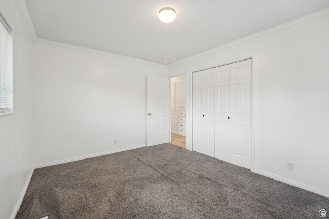 unfurnished bedroom with ornamental molding, baseboards, a closet, and carpet