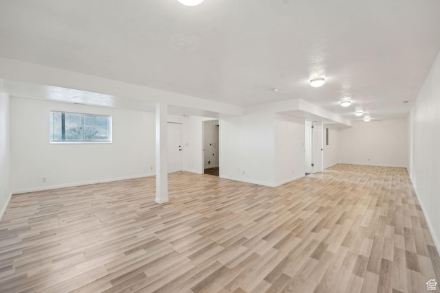 basement featuring light wood-type flooring and baseboards