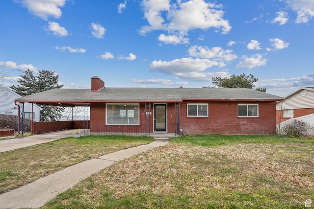 ranch-style home with a carport, a front lawn, brick siding, and concrete driveway