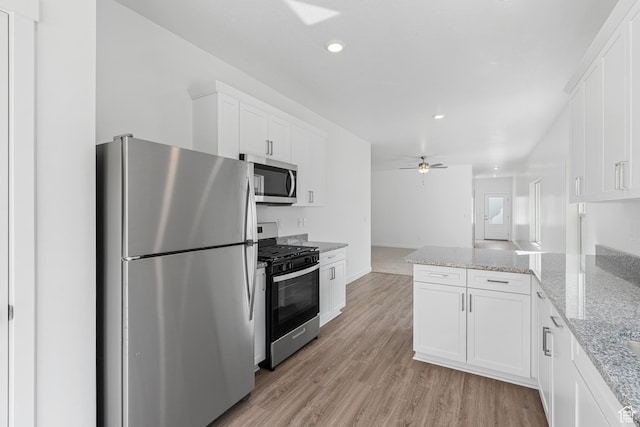 7137 Oquirrh Ranch Pkwy N, Eagle Mountain, UT 84005 - kitchen featuring ceiling fan, appliances with stainless steel finishes, a peninsula, white cabinetry, and light wood finished floors