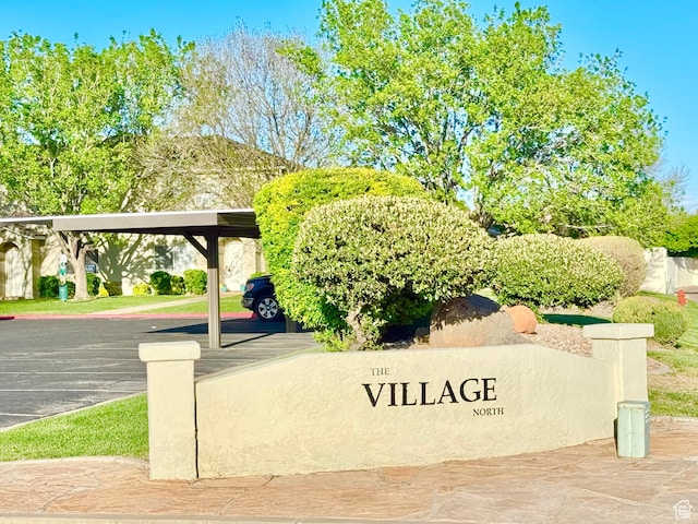 community / neighborhood sign featuring covered and uncovered parking