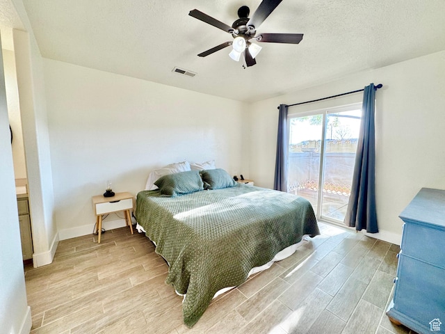 bedroom featuring light wood-type flooring, a textured ceiling, visible vents, access to exterior, and ceiling fan