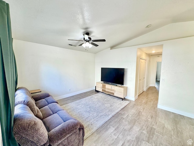 living room featuring baseboards, visible vents, lofted ceiling, light wood finished floors, and ceiling fan