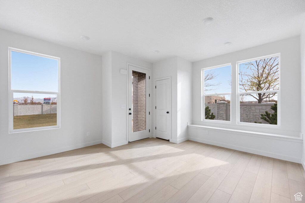 unfurnished room with light wood-style flooring and baseboards