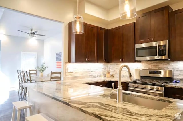 4277 W Canterbury Rd, Hurricane, UT 84737 - kitchen with light stone counters, ceiling fan, backsplash, and stainless steel appliances