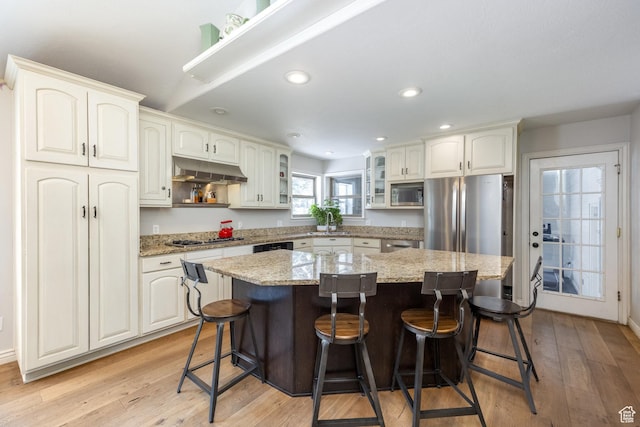 9106 N Upper Lando Ln, Park City, UT 84098 - kitchen with stainless steel appliances, under cabinet range hood, a kitchen bar, a center island, and recessed lighting
