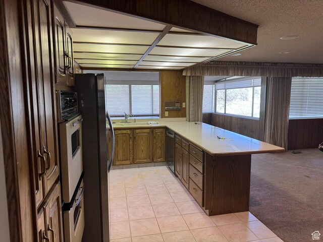 871 N Bonita Way E Unit 19, Centerville, UT 84014 - kitchen with light countertops, freestanding refrigerator, white oven, dishwashing machine, and light colored carpet