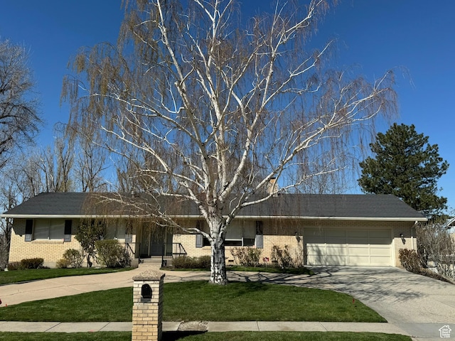 ranch-style home with concrete driveway, brick siding, an attached garage, and a front lawn