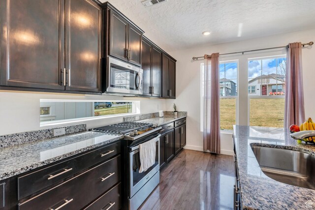 6156 W Poplar View Dr, South Jordan, UT 84009 - kitchen with dark wood-type flooring, a textured ceiling, light stone counters, a sink, and stainless steel appliances