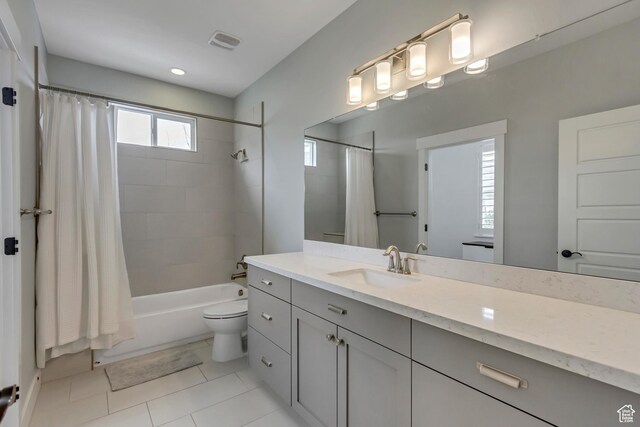 full bathroom featuring visible vents, toilet, shower / bathtub combination with curtain, vanity, and tile patterned floors