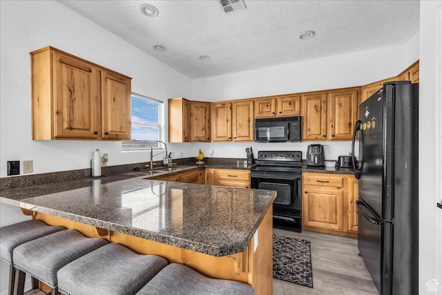 1277 W Las Hurdes Dr, St George, UT 84770 - kitchen featuring brown cabinetry, a peninsula, a sink, and black appliances