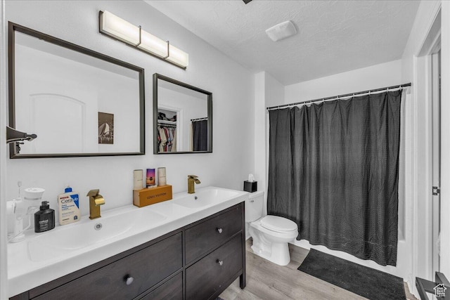 1277 W Las Hurdes Dr, St George, UT 84770 - bathroom featuring a sink, toilet, a textured ceiling, double vanity, and wood finished floors