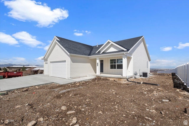ranch-style house with central AC, a garage, fence, concrete driveway, and roof with shingles