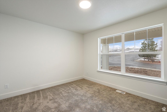 spare room with visible vents, baseboards, and carpet