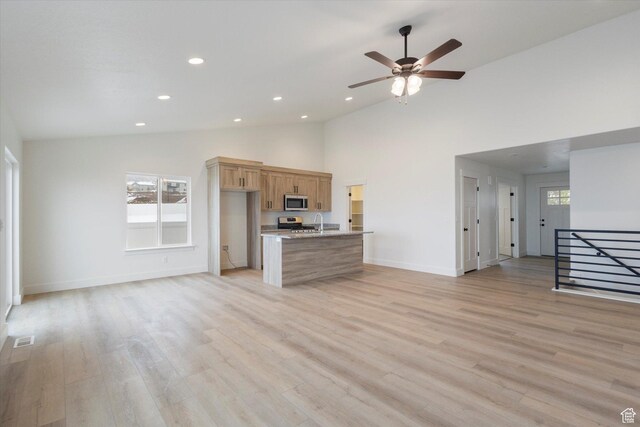 unfurnished living room featuring light wood-style floors, visible vents, and a wealth of natural light