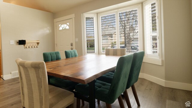 dining area featuring a healthy amount of sunlight, wood finished floors, baseboards, and visible vents
