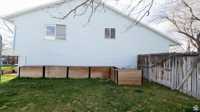 back of house with fence and a lawn