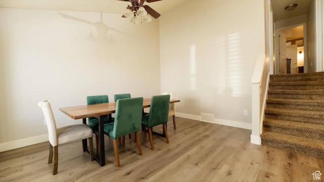 dining room with baseboards, stairway, a ceiling fan, light wood-style floors, and visible vents
